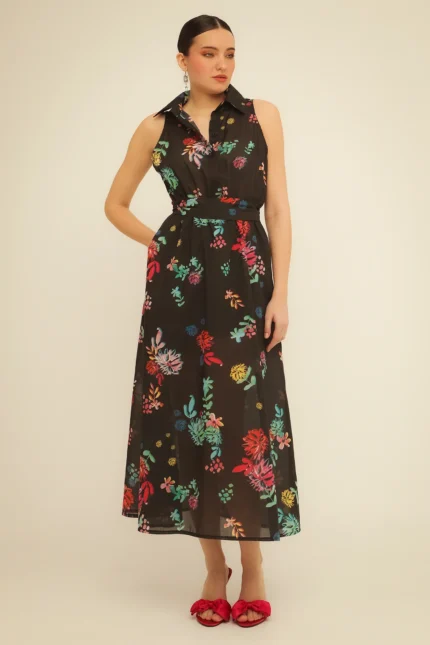 Η γυναίκα φοράει το Black Grace Dress της Bee me, ένα κομψό μαύρο φόρεμα, σε φωτεινή λήψη.